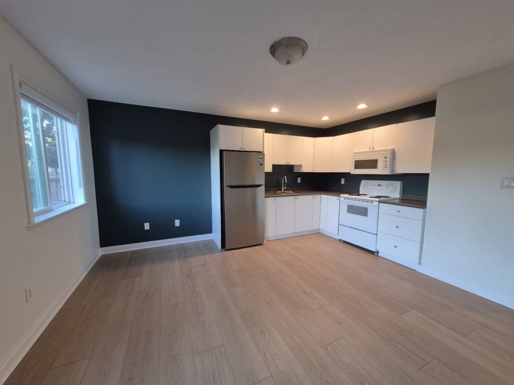 Open-plan kitchen and living area with new wood-look plank flooring - Pi Floor & Blinds Victoria BC