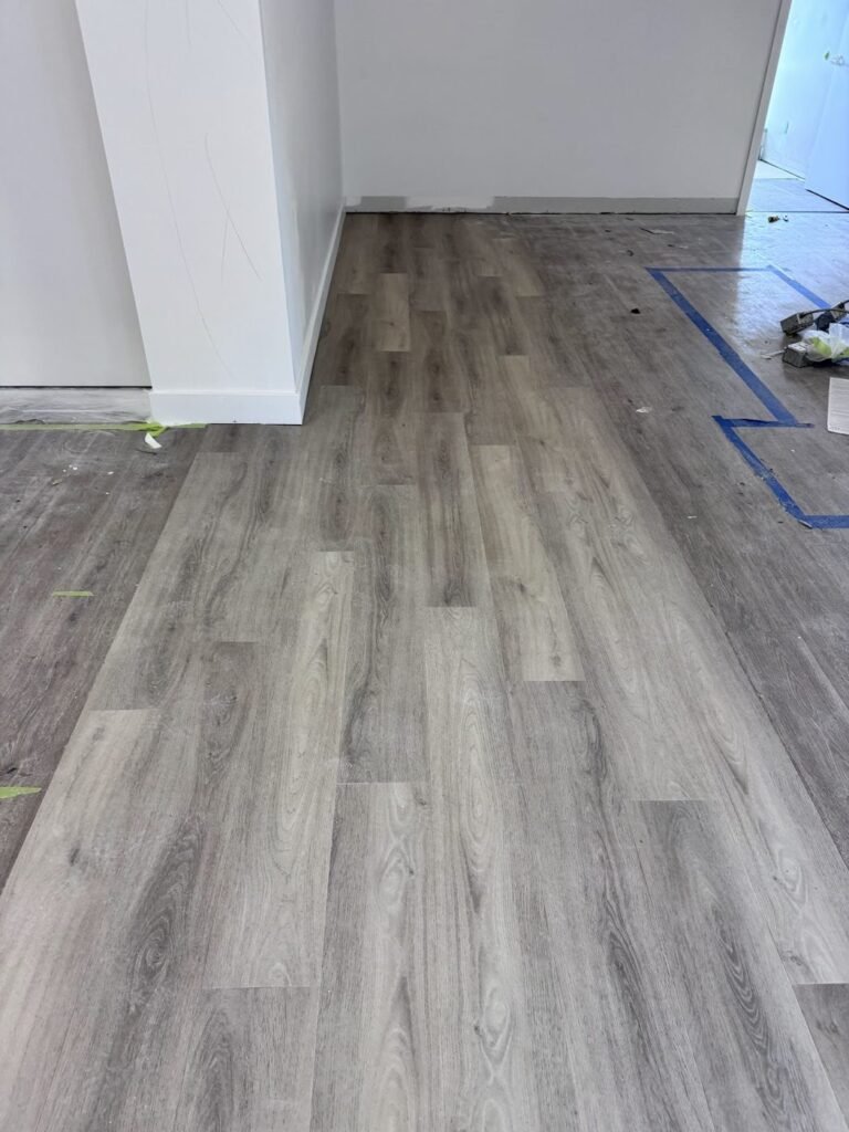 Long hallway with new grey wood-look plank flooring - Pi Floor & Blinds Victoria BC