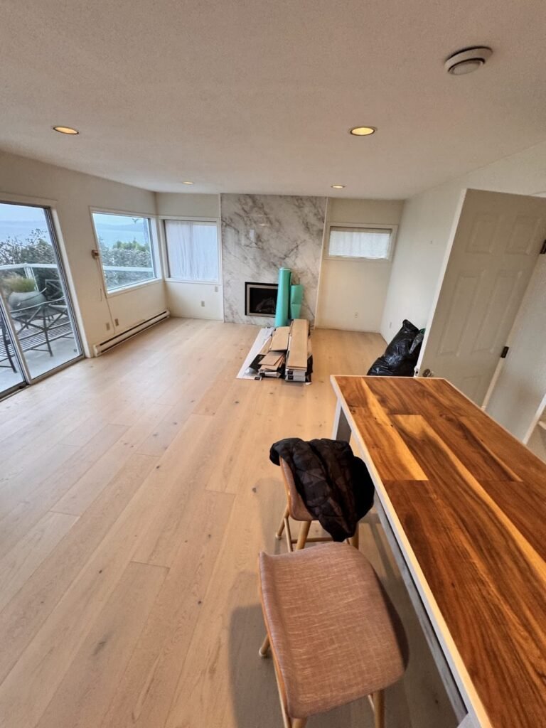 Open room with warm wood flooring and a butcher-block counter - Pi Floor & Blinds Victoria BC